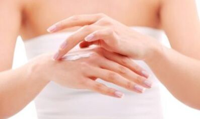 djevojka koja nanosi mast na ruku